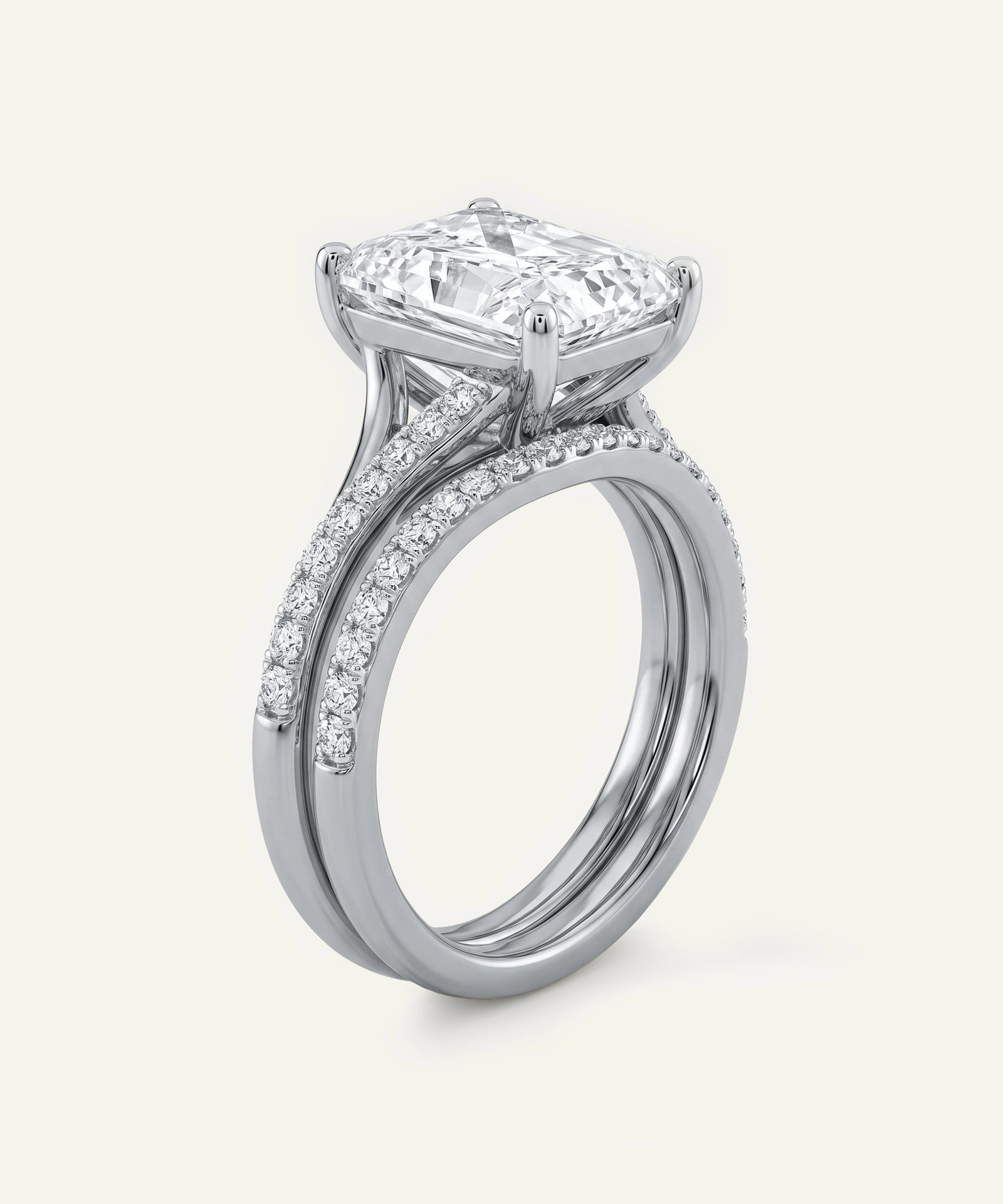 Side view of a radiant-cut diamond engagement ring and matching pavé wedding band.
