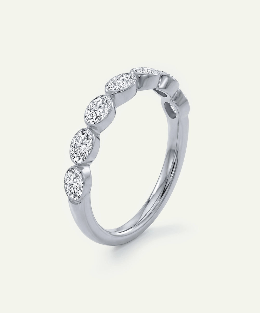 Silver ring with oval-shaped diamonds on a light gray background