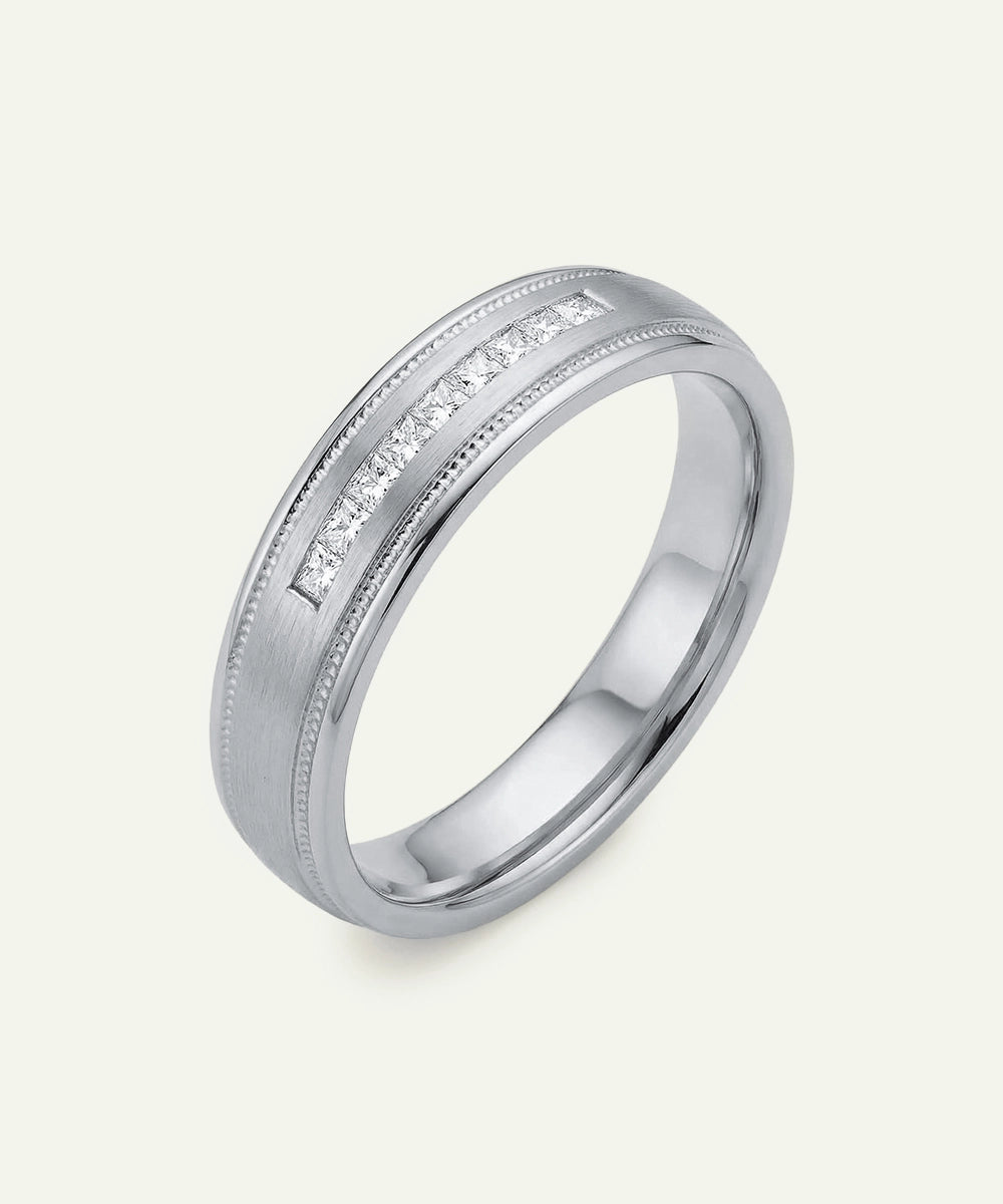 Silver ring with embedded diamonds on a light gray background