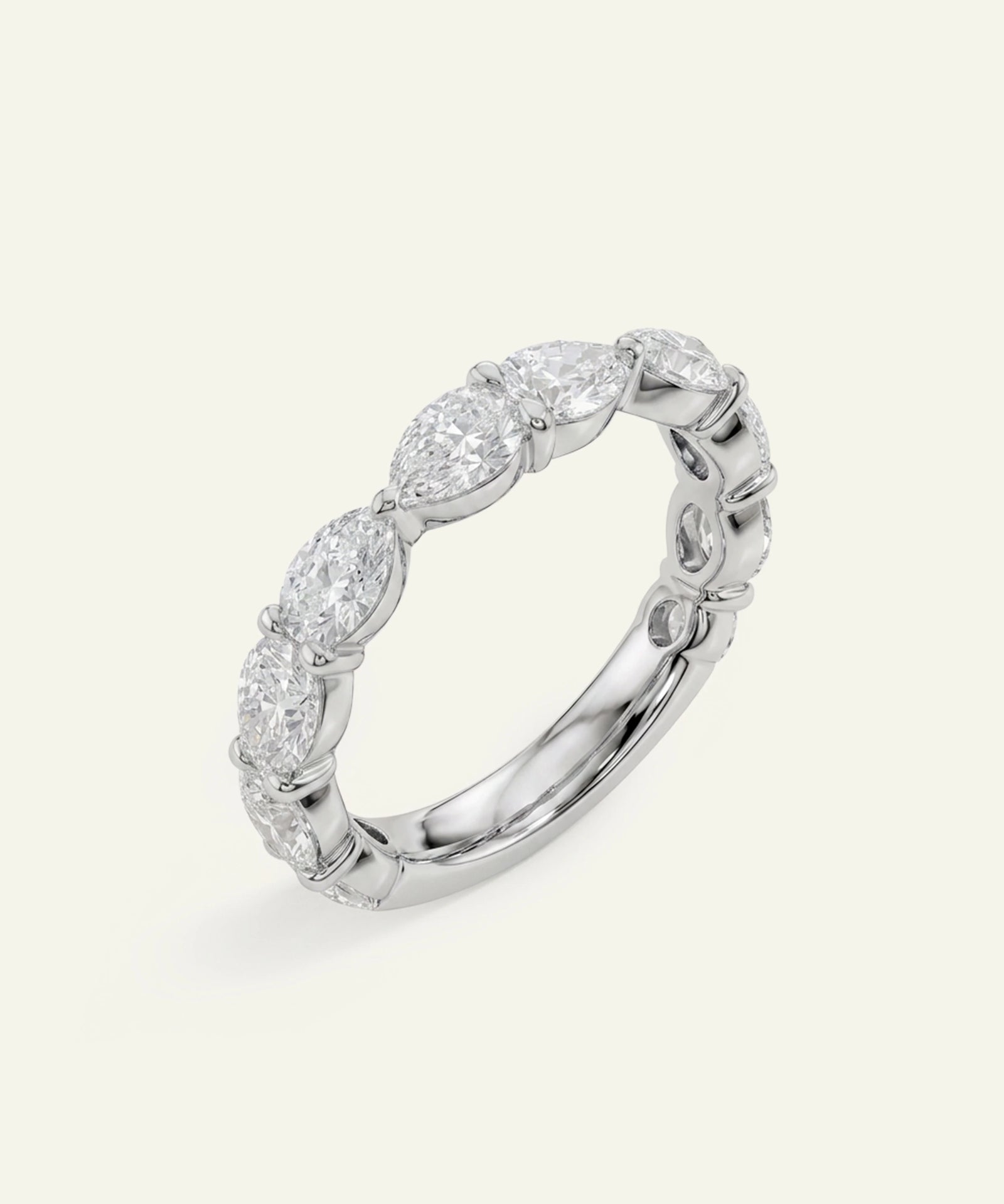 A silver diamond eternity ring featuring a continuous row of marquise-cut diamonds set in a polished silver band, shown on a light cream background.