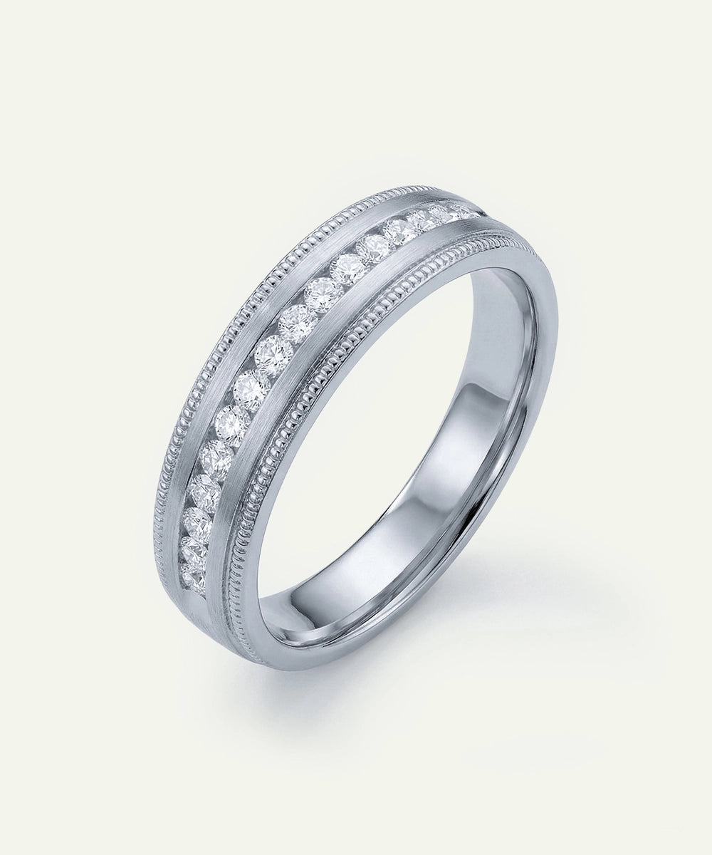 Silver ring with embedded diamonds on a light gray background