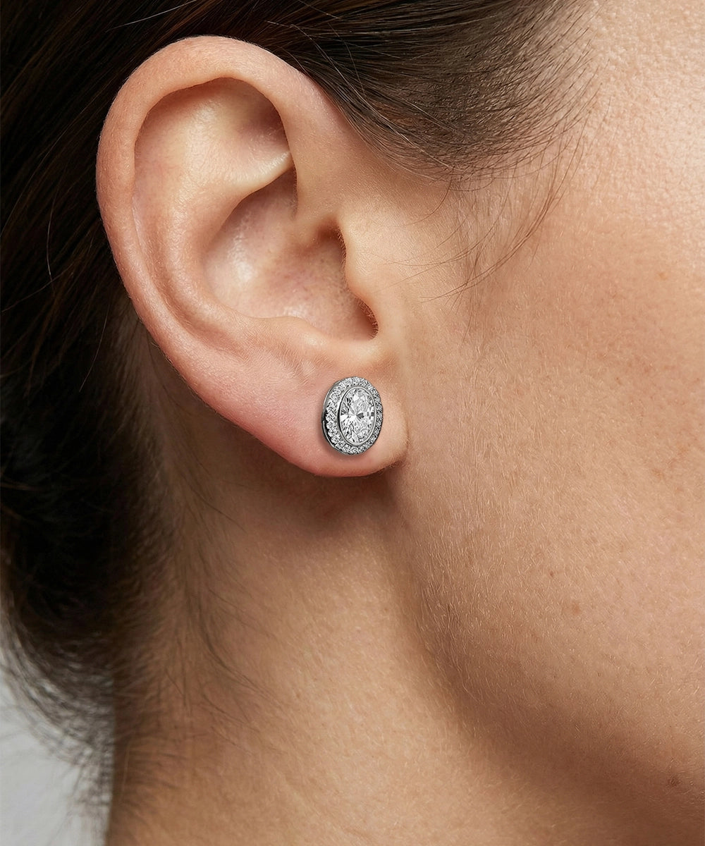 Close-up of an ear wearing a diamond earring with a blurred background